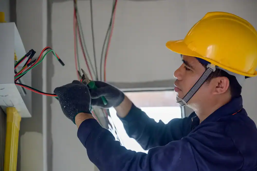 A skilled electrician carefully working on electrical wiring in Tarrant County, Texas, ensuring safety and quality for a residential property by Carroll Service